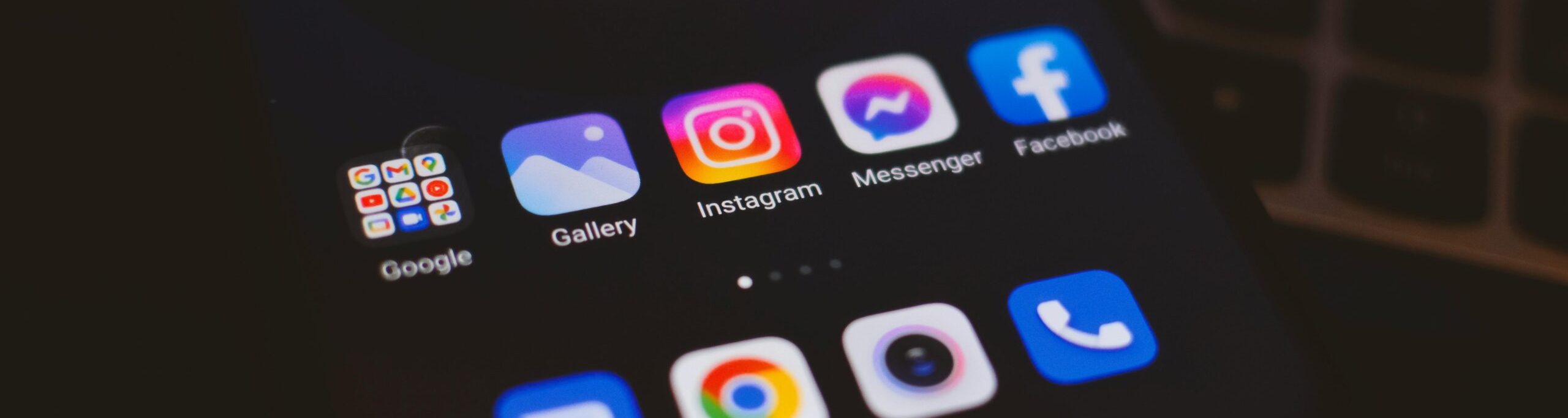 A smartphone displaying popular social media apps in a dimly lit environment, perfect for tech and communication themes.